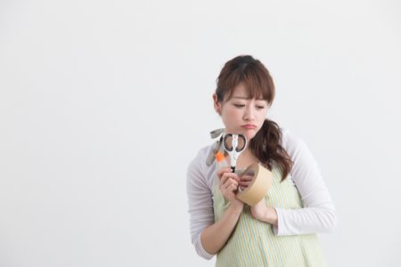 ハサミとガムテを持つ女性